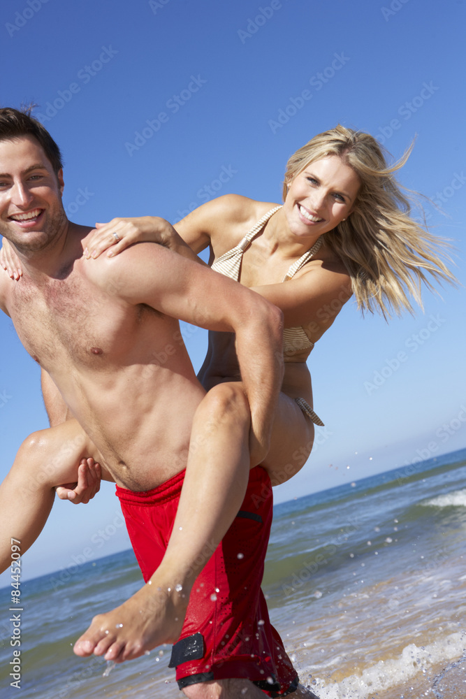Couple Having Fun On Beach Holiday Together Couple Having Fun On Beach Holiday Together