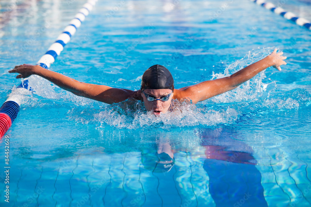 Butterfly swimmer in cap and glasses  the pool