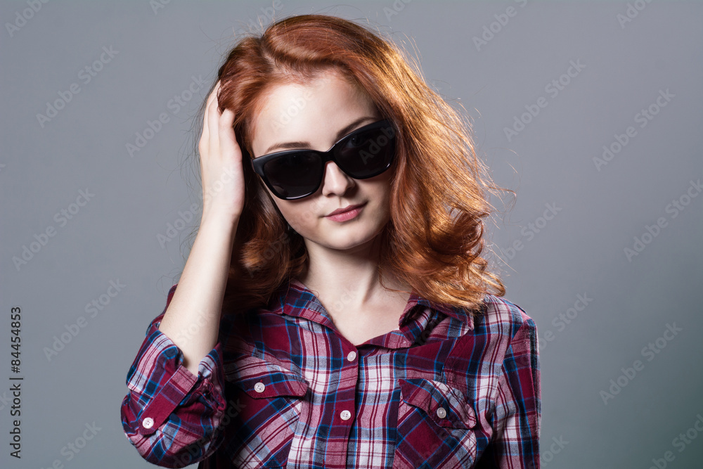 Portrait of a smiling beautiful young red-haired girl in sunglas Portrait of a smiling beautiful young red-haired girl in sunglas