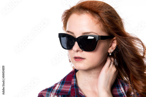 Close-up portrait of red-haired girl with sunglasses looking to © kanzefar