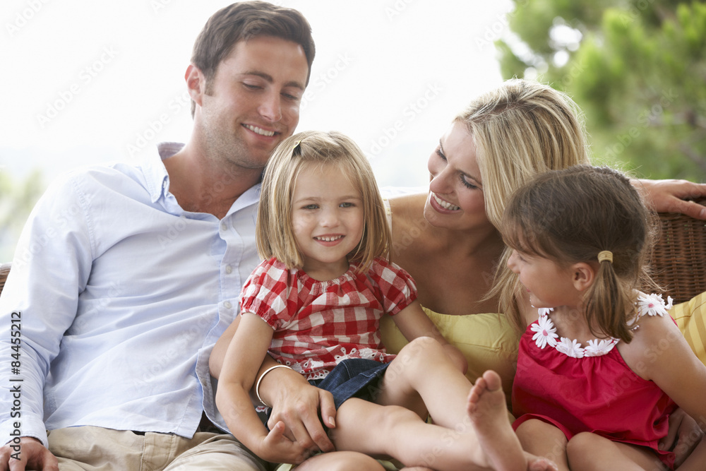 Family Sitting  On Garden Seat Together