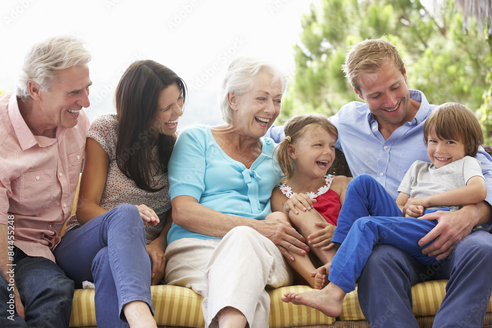 Multi Generation Family Sitting On Garden Seat