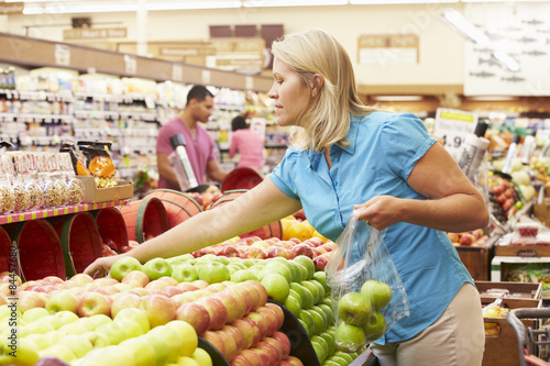 Woman At Fruit Counter In Supermarket