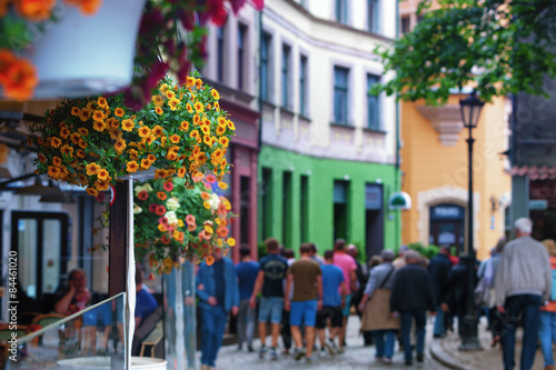 Tourists walking along the street of the old town with flowers i © victorgrow
