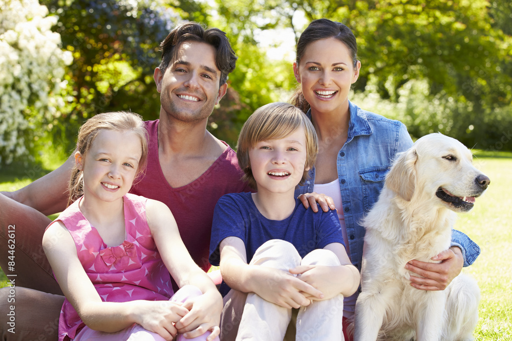 Portrait Of Family With Dog Relaxing In Summer Garden Portrait Of Family With Dog Relaxing In Summer Garden