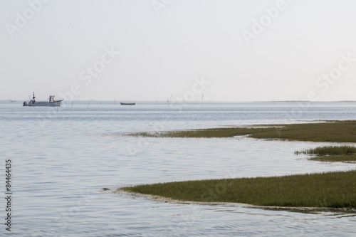 View of a lonely fisherman boat on the marshlands of Ria Formosa, Algarve.
