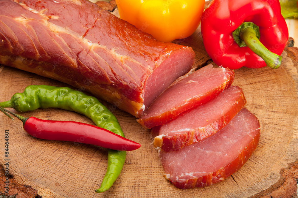 Smoked meat with bright summer vegetables on wooden background Smoked meat with bright summer vegetables on wooden background