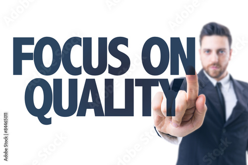 Business man pointing the text: Focus On Quality