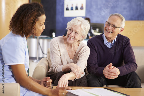 Senior Couple Meeting With Nurse In Hospital