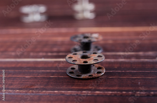 Vintage sewing machine bobbins on wooden background