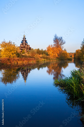 landscape with a wooden church over the river