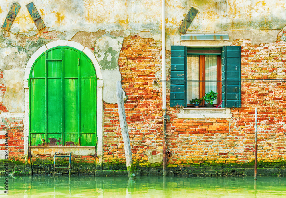 Old green iron door over a canal in Venice, Italy.