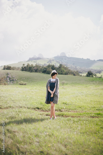 Young pretty woman in a straw hat posing on a green meadow  © polinaloves