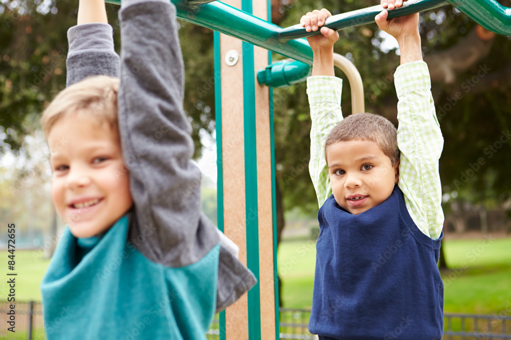 Two Young Boys On Climbing Frame In Playground Two Young Boys On Climbing Frame In Playground