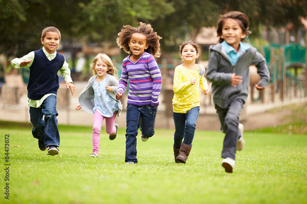 Group Of Young Children Running Towards Camera In Park - obrazy, fototapety, plakaty 