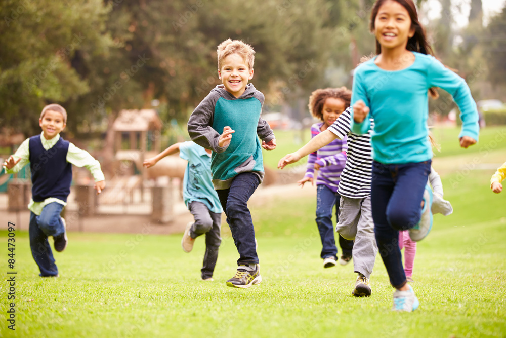 Group Of Young Children Running Towards Camera In Park Group Of Young Children Running Towards Camera In Park