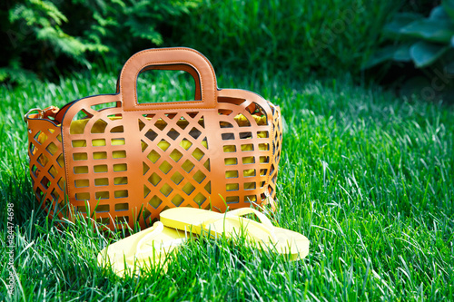 front view of orange purse on green grass photo