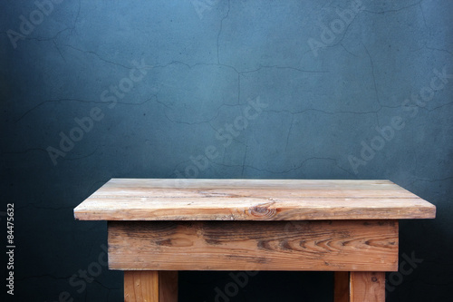 пустой деревянный стол на фоне стены с трещинами