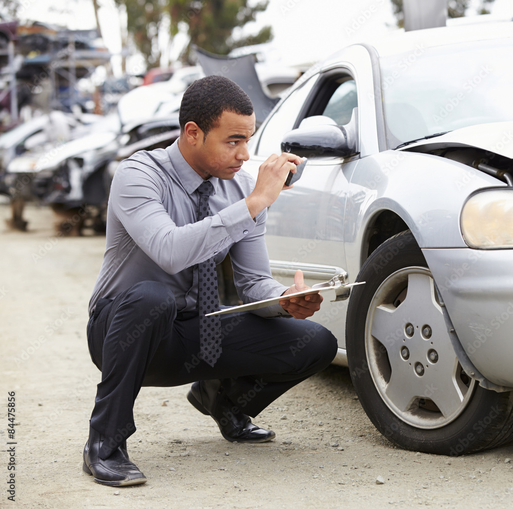 Loss Adjuster Taking Photograph Of Damage To Car Loss Adjuster Taking Photograph Of Damage To Car
