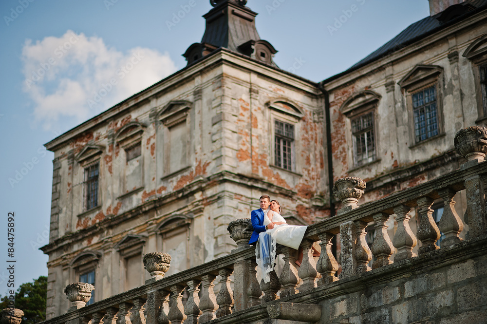 Fototapeta premium Young wedding couple on background old castle