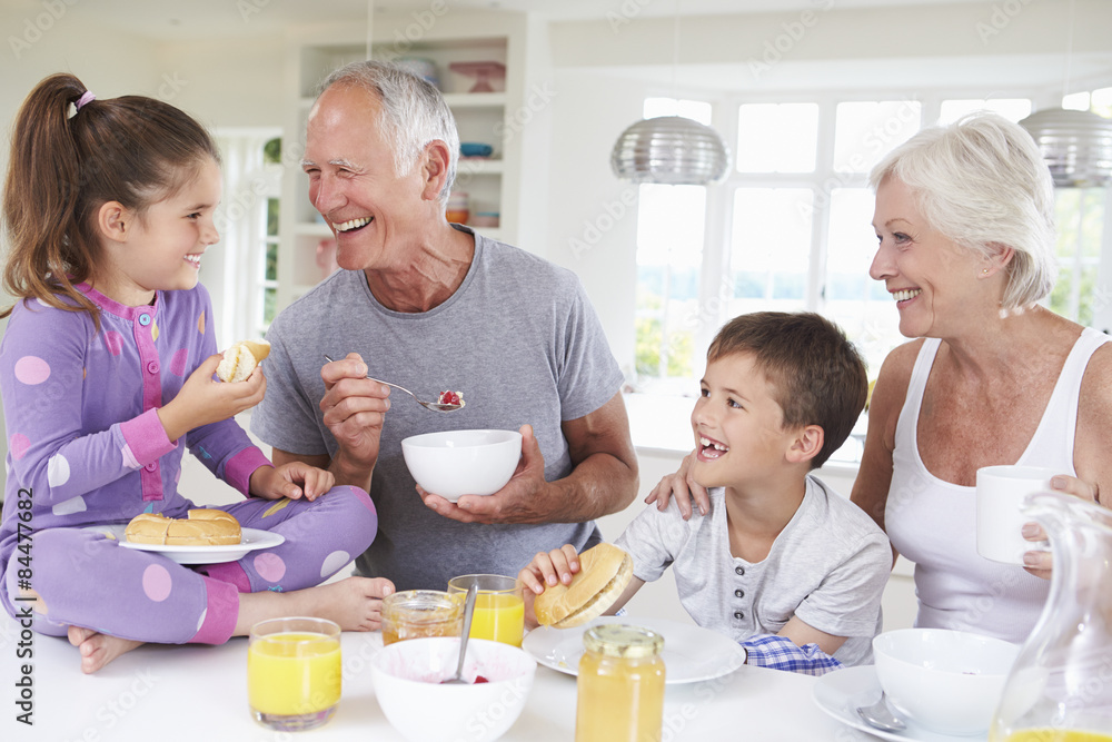 Grandparents With Grandchildren Eating Breakfast In Kitchen Grandparents With Grandchildren Eating Breakfast In Kitchen