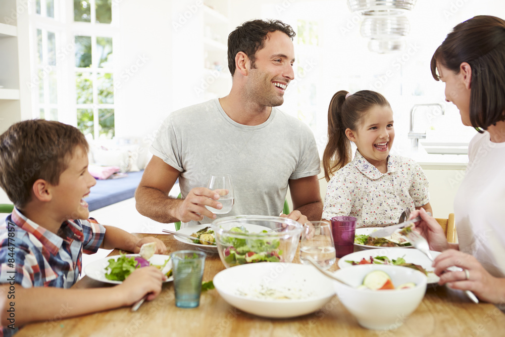Family Eating Meal Around Kitchen Table Together Family Eating Meal Around Kitchen Table Together
