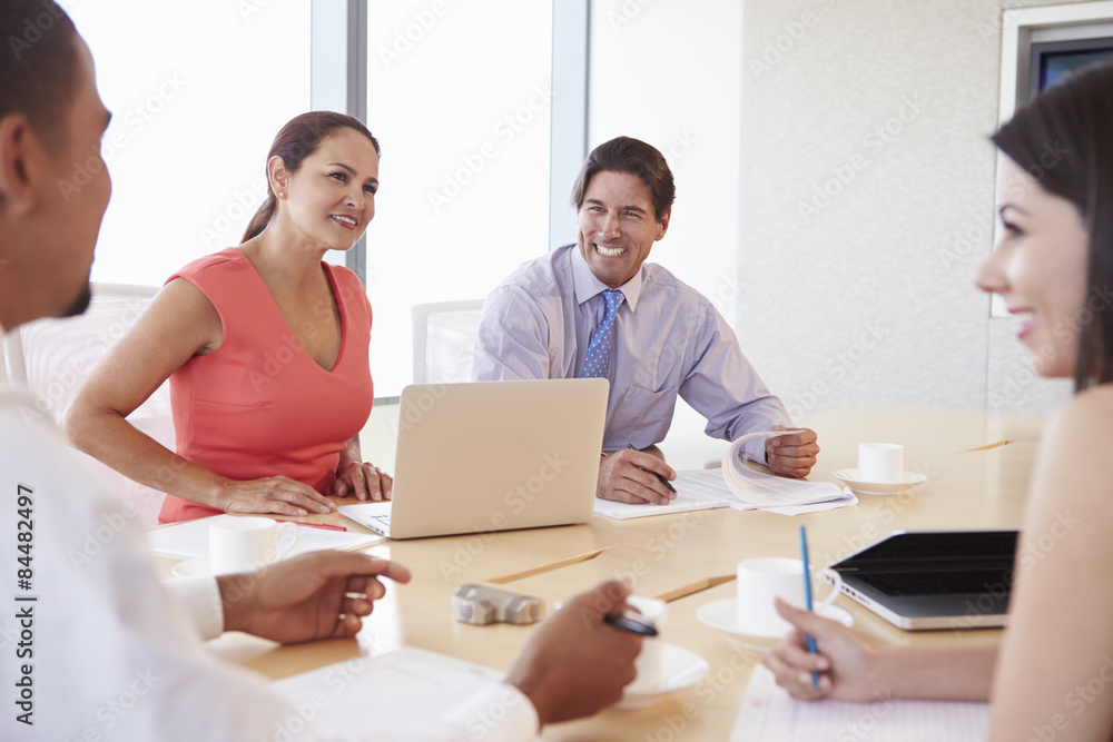 Four Hispanic Businesspeople Having Meeting In Boardroom Four Hispanic Businesspeople Having Meeting In Boardroom