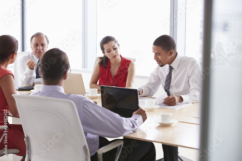 Five Businesspeople Having Meeting In Boardroom