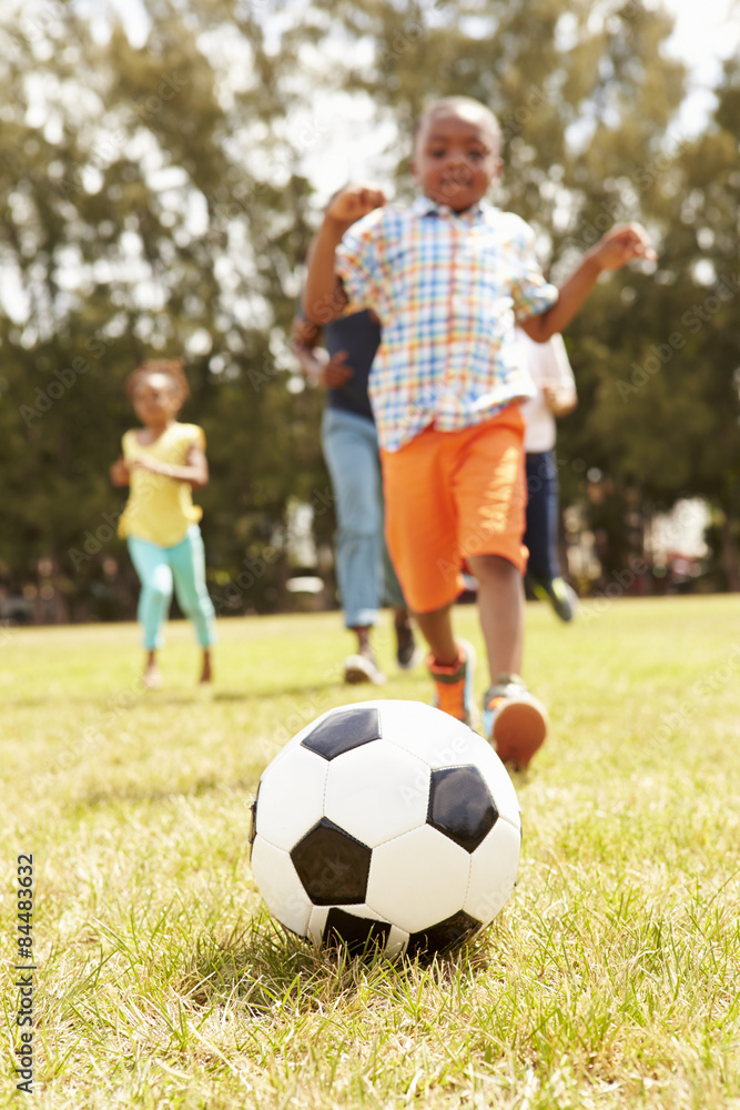 Family Playing Soccer In Park Together Family Playing Soccer In Park Together