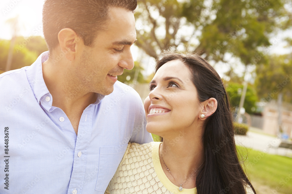 Young Hispanic Couple Walking In Park Together Young Hispanic Couple Walking In Park Together