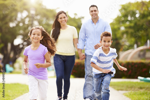 Hispanic Family Walking In Park Together