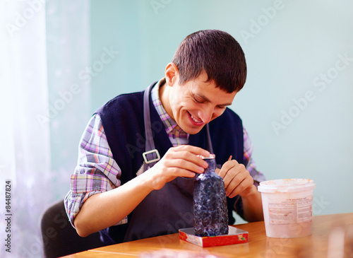 young adult man with disability engaged in craftsmanship on prac