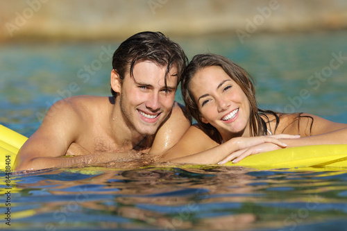 Happy couple bathing on the beach in summer vacation