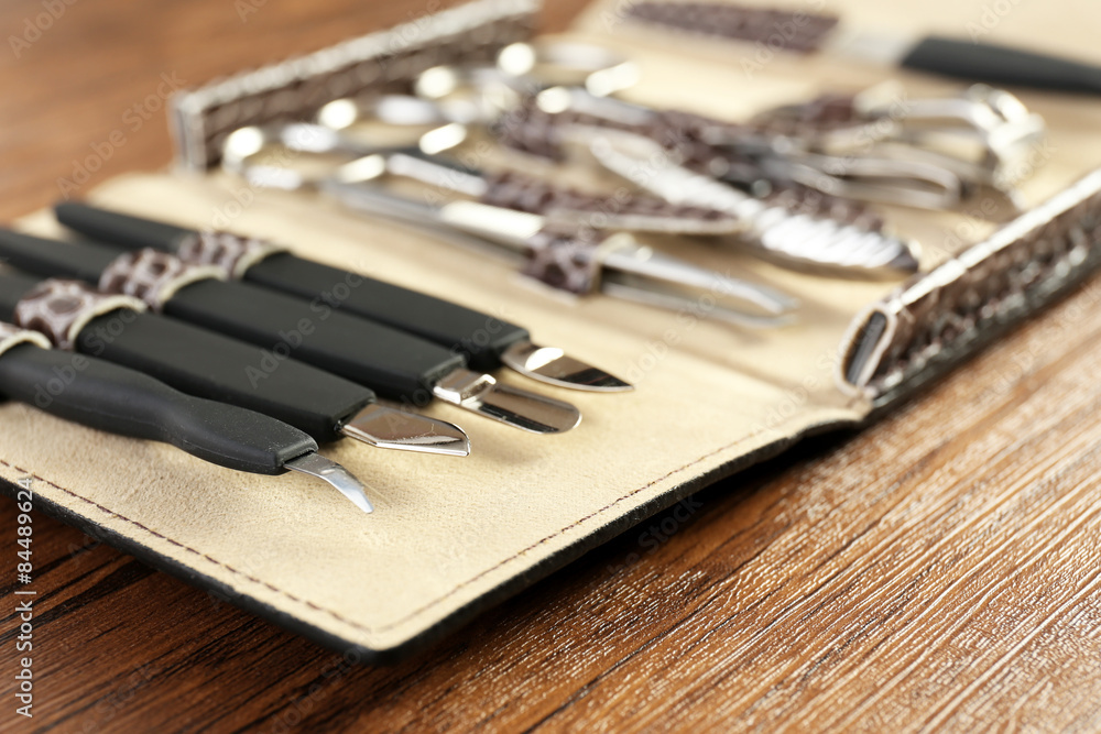 Manicure set in open case on wooden table, closeup Manicure set in open case on wooden table, closeup
