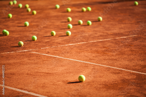 Tennis balls on the clay court. © Pitcher