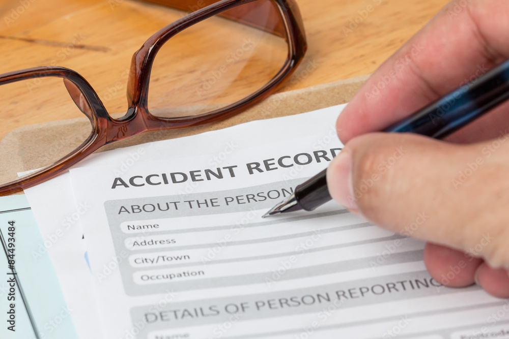 Accident report application form and human hand with pen on brow Accident report application form and human hand with pen on brow