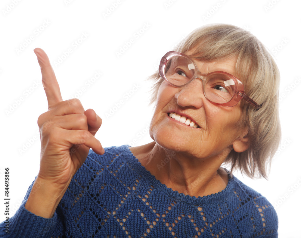happy senior woman pointing upwards 