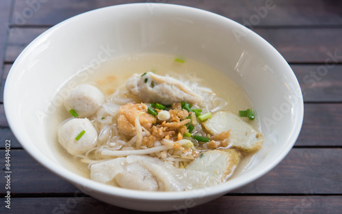 Fish ball noodle in cup on wood table background