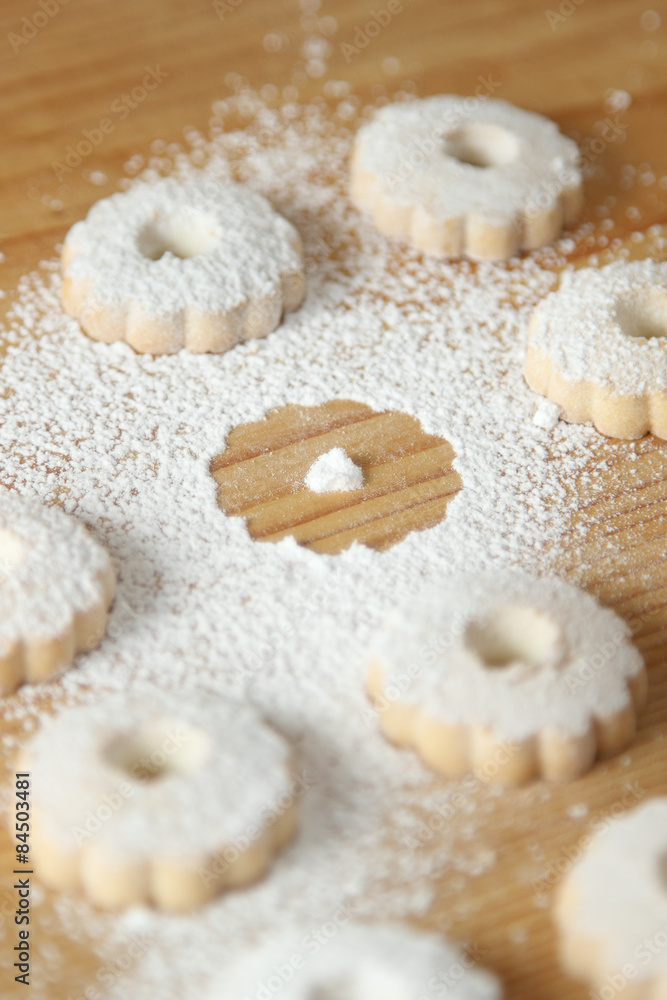 Italian canestrelli biscuits sprinkled with powdered sugar with a missing cookie