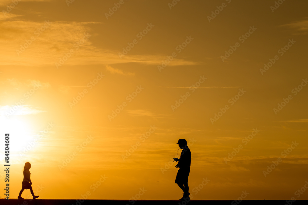 Silhouette people walking at sunset