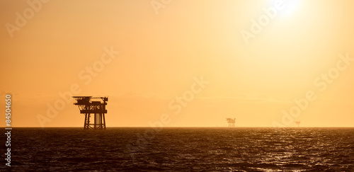 Tableau sur toile Silhouette of oil platform at sunset