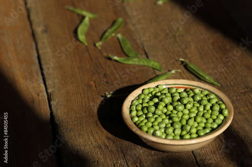 Pea in a ceramic bowl on the wooden background