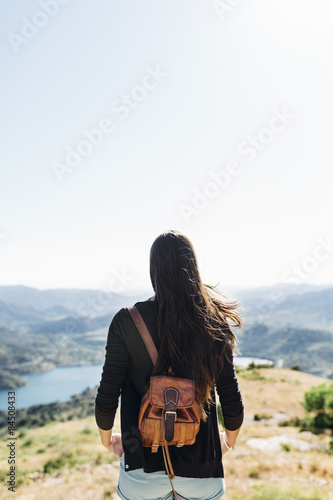 young woman on top of a mountain with view