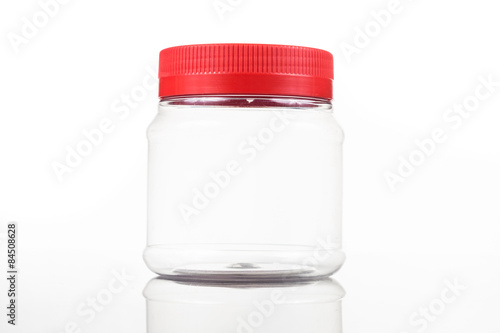 Fotótapéta Translucent plastic PVC jar with red cover isolated in white