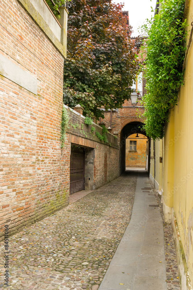 Small ancient street in the old downtown of Ferrara, Italy