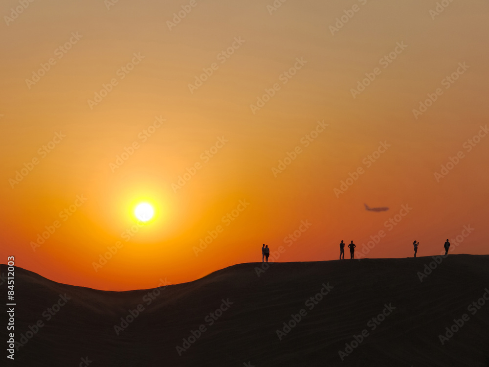 People make photo in the desert at the sunset