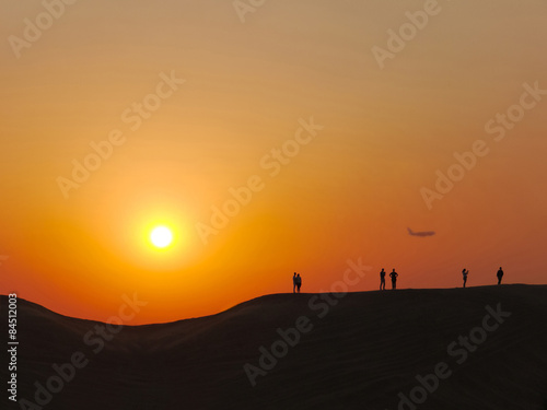 People make photo in the desert at the sunset