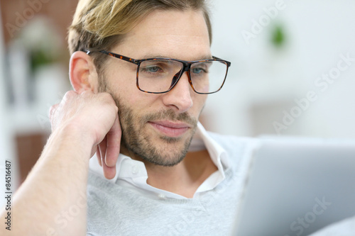 Man with eyeglasses connected on digital tablet at home