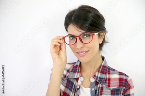 Portrait of brunette girl with red eyeglasses on, isolated