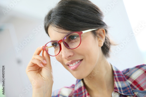 Portrait of brunette girl with red eyeglasses on, isolated